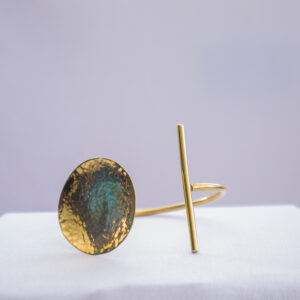 Kenyan-made brass bracelet with concave design and adjustable wrist band.
