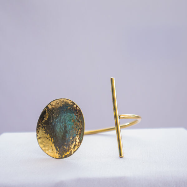 Kenyan-made brass bracelet with concave design and adjustable wrist band.