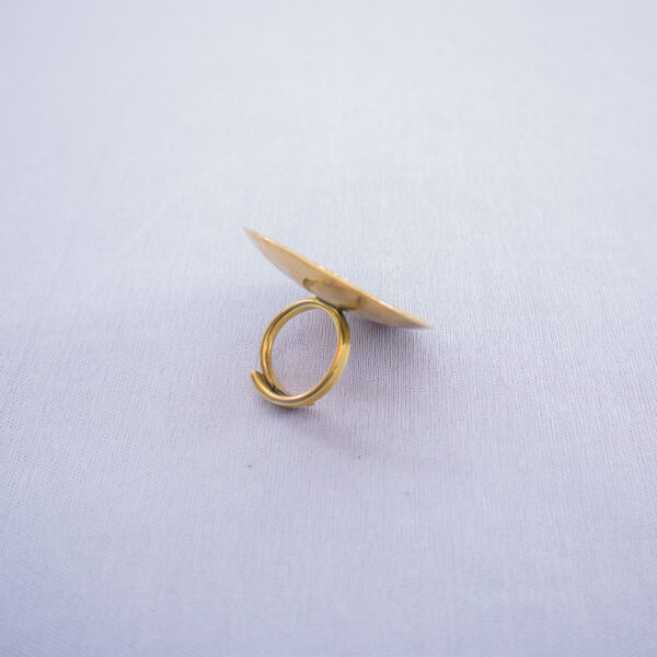 Handmade brass statement ring with concave design and adjustable band.
