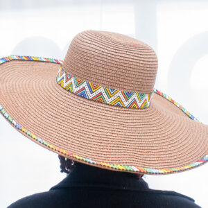 Wide sun hat otherwise called a straw hat that has beaded details on rim and at the middle