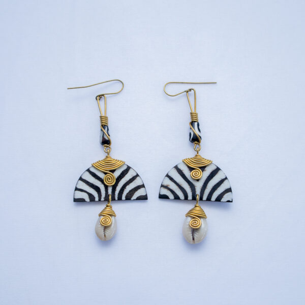 A pair of handcrafted dangling earrings. Made from bone with zebra pattern and delicate brass wire detail.