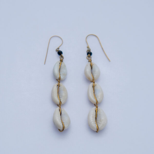 Dangling earrings featuring natural cowrie shells with intricate brass detail. Lightweight,perfect for casual wear.