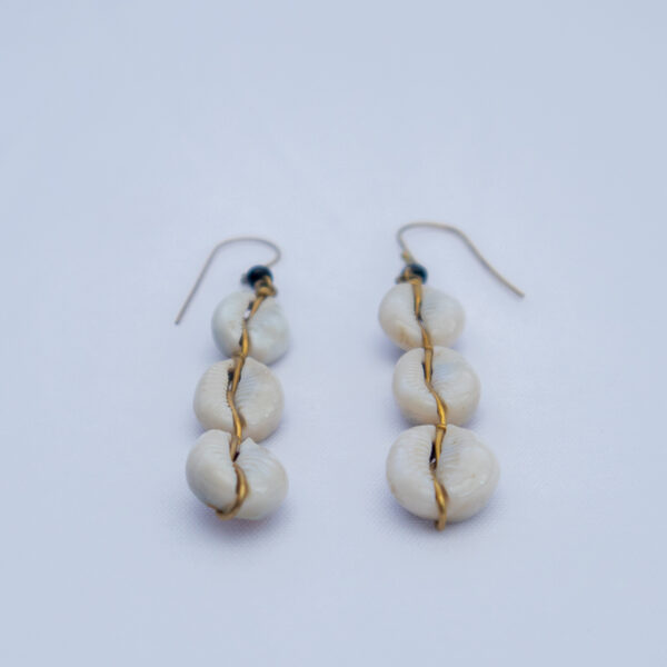 Dangling earrings featuring natural cowrie shells with intricate brass detail. Lightweight,perfect for casual wear.