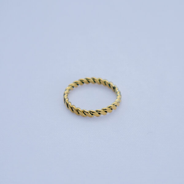 Minimalistic brass ring with rope-like twisted design and a smooth texture.