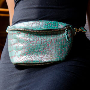 Afrostyled teal crossbody bag with crocodile texture and a minimalist design.