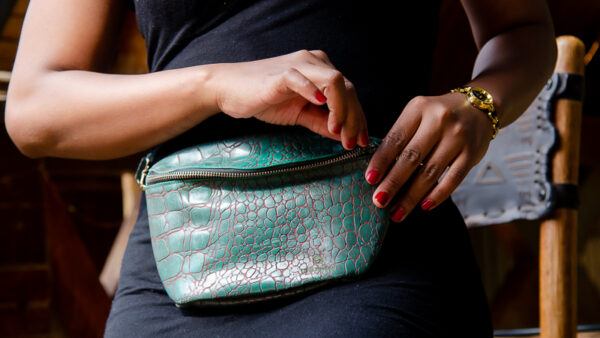 Afrostyled teal crossbody bag with crocodile texture and a minimalist design.