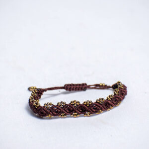 Handwoven brown cord bracelet with shiny gold-like beads and adjustable closure.