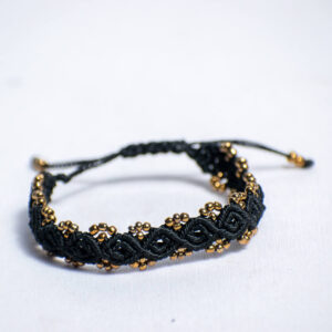 Handwoven black cord bracelet with shiny gold-like beads and adjustable closure.