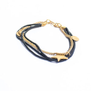 Black beaded anklet with a brass chain and star-shaped brass charm.