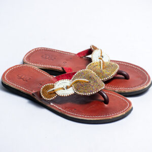 Brown leather sandals with hand-beaded circular detailing and stitched grip soles.