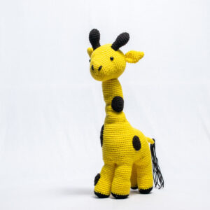 Hand-crocheted yellow giraffe toy with black details.