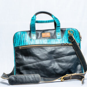 Handmade black leather laptop case with bold blue and black patterned accents, sturdy handles, and shoulder strap