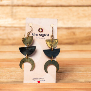A pair of handcrafted tiered drop earrings featuring a golden brass semi-circle at the top, a dark black semi-circular link in the middle, and a golden brass crescent moon shape at the bottom.
