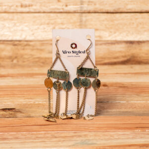 A pair of handcrafted golden brass chandelier drop earrings featuring a horizontal rectangular metal bar linked to three textured circular discs, with delicate metallic chains dangling from the discs and distinctive triangular charms pooling at the bottom.
