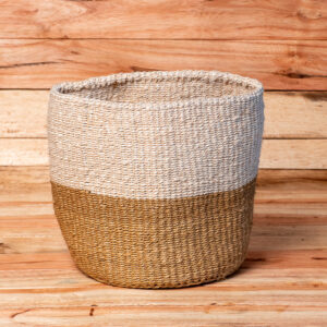 A cylinder-shaped handwoven sisal open basket featuring a color-blocked design with a cream white top half and a natural tan bottom half.