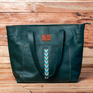 A dark green pebble-grained leather tote bag with a front slip pocket featuring a central vertical stripe of turquoise and white chevron-patterned beadwork.