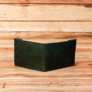 An open bifold wallet made of deep forest green leather, showing the smooth exterior on one side and multiple interior card slots with green stitching on the other.
