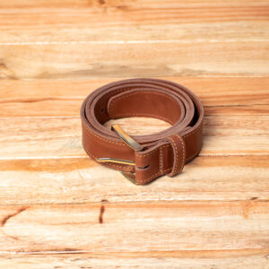 A coiled genuine tan leather belt featuring a polished metal buckle and distinctive yellow accent stitching along the edges.