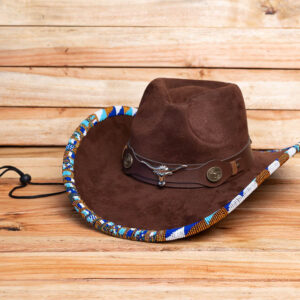 A brown suede cowboy hat decorated with a colorful beaded brim edge and a leather band with silver bull emblem details.