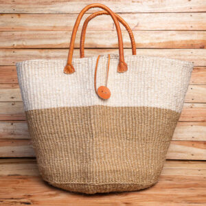A large two-tone woven sisal tote bag in cream and tan with leather top handles and a leather toggle closure.