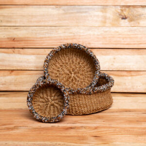 Handcrafted in Kenya from natural woven sisal fibers, this set of nesting decorative bowls features intricate glass beadwork along the rims. The shimmering black, gold, and white seed beads add a refined, tactile accent to the natural, earthy texture of the woven sisal. Perfect for holding keys, jewelry, or small treasures, or simply displayed as an eye-catching tabletop centerpiece.