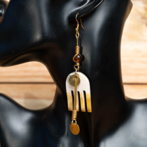 A long brass and horn drop earring featuring wire-wrapped beads, a gradient horn pendant with cutouts, and small brass disc charms.